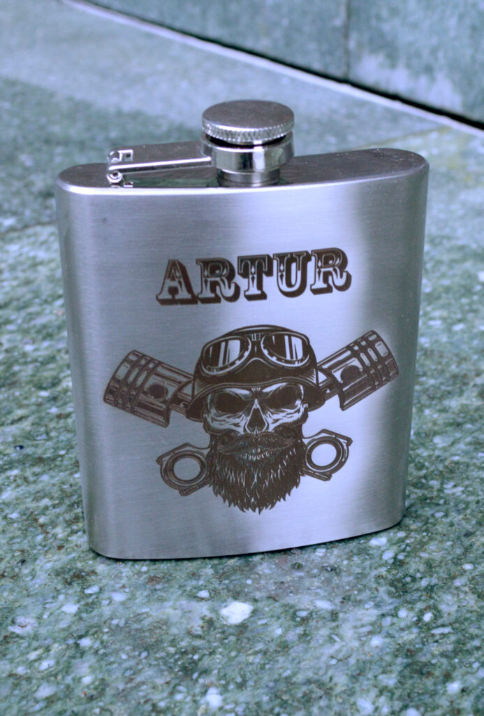 Metalowa personalizowana piersiówka z motywem czaszki i imieniem.